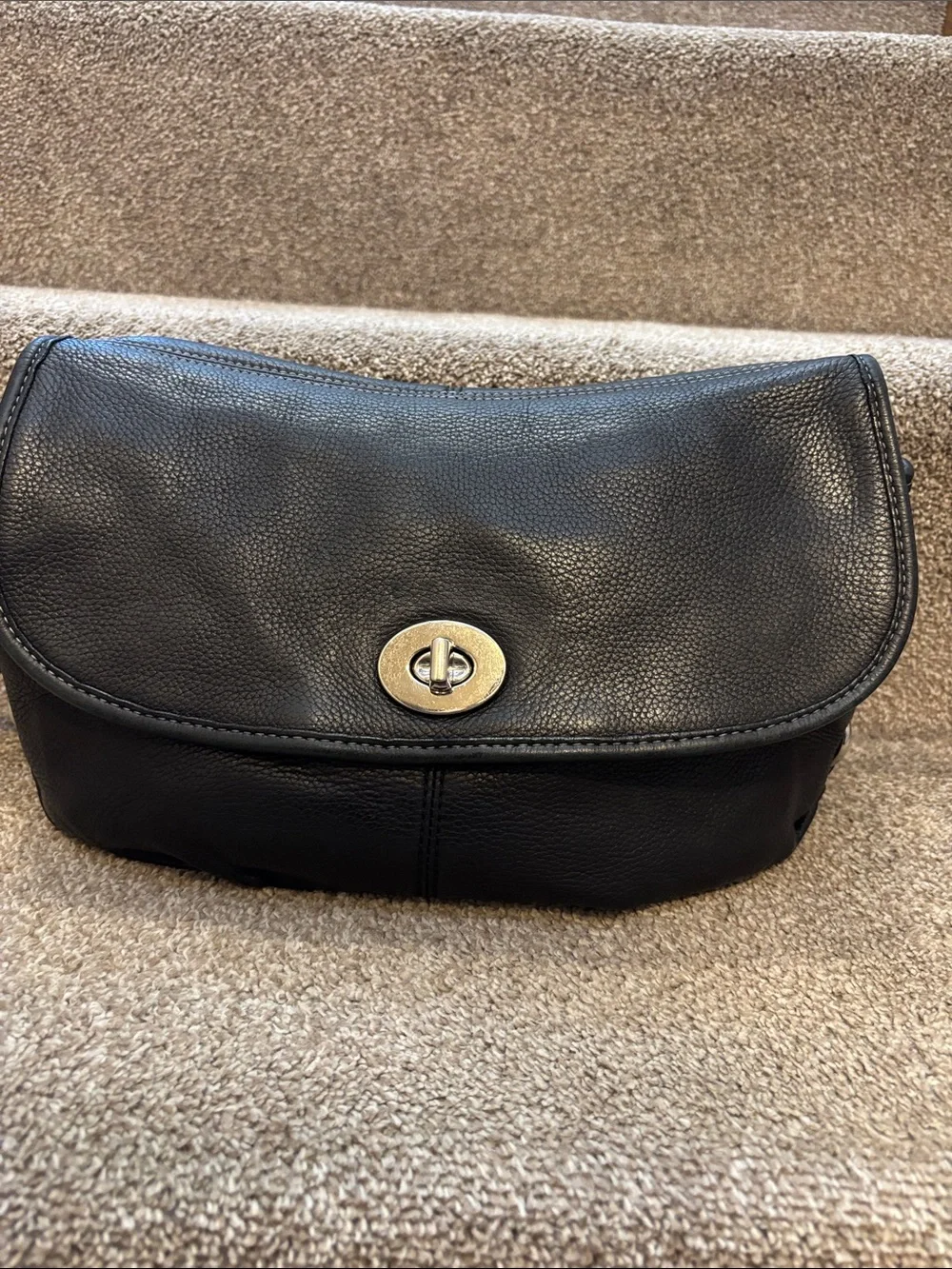 This is a vintage black pebbled leather Coach Legacy flap bag